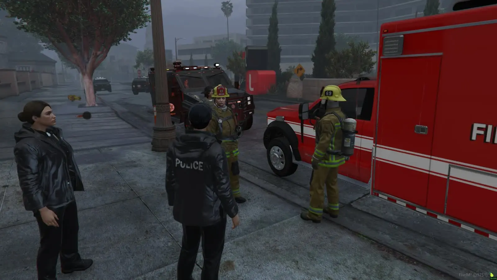 Police and fire crews gathered by an ambulance in fog
